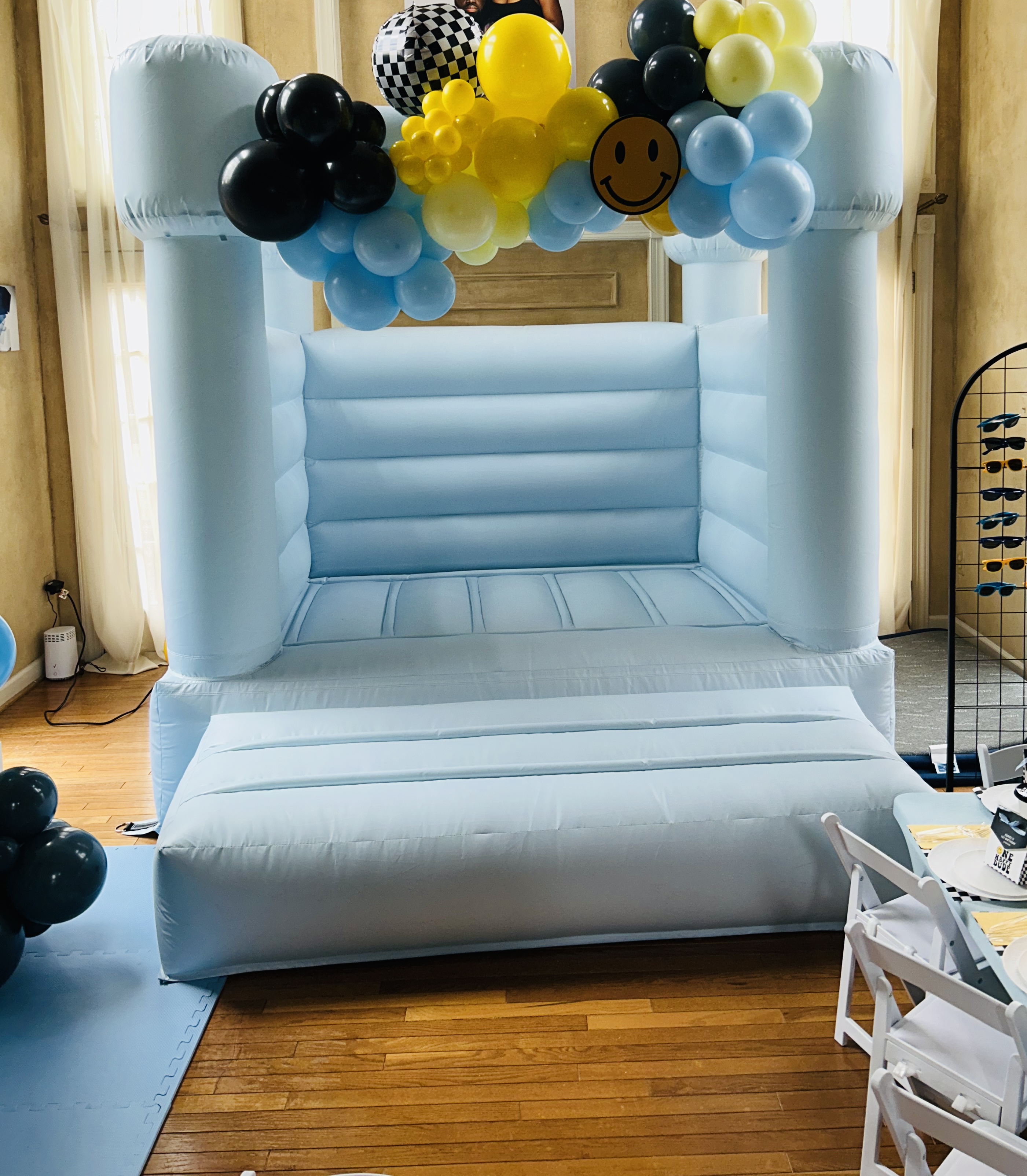Blue pastel mini bounce house with balloon garland