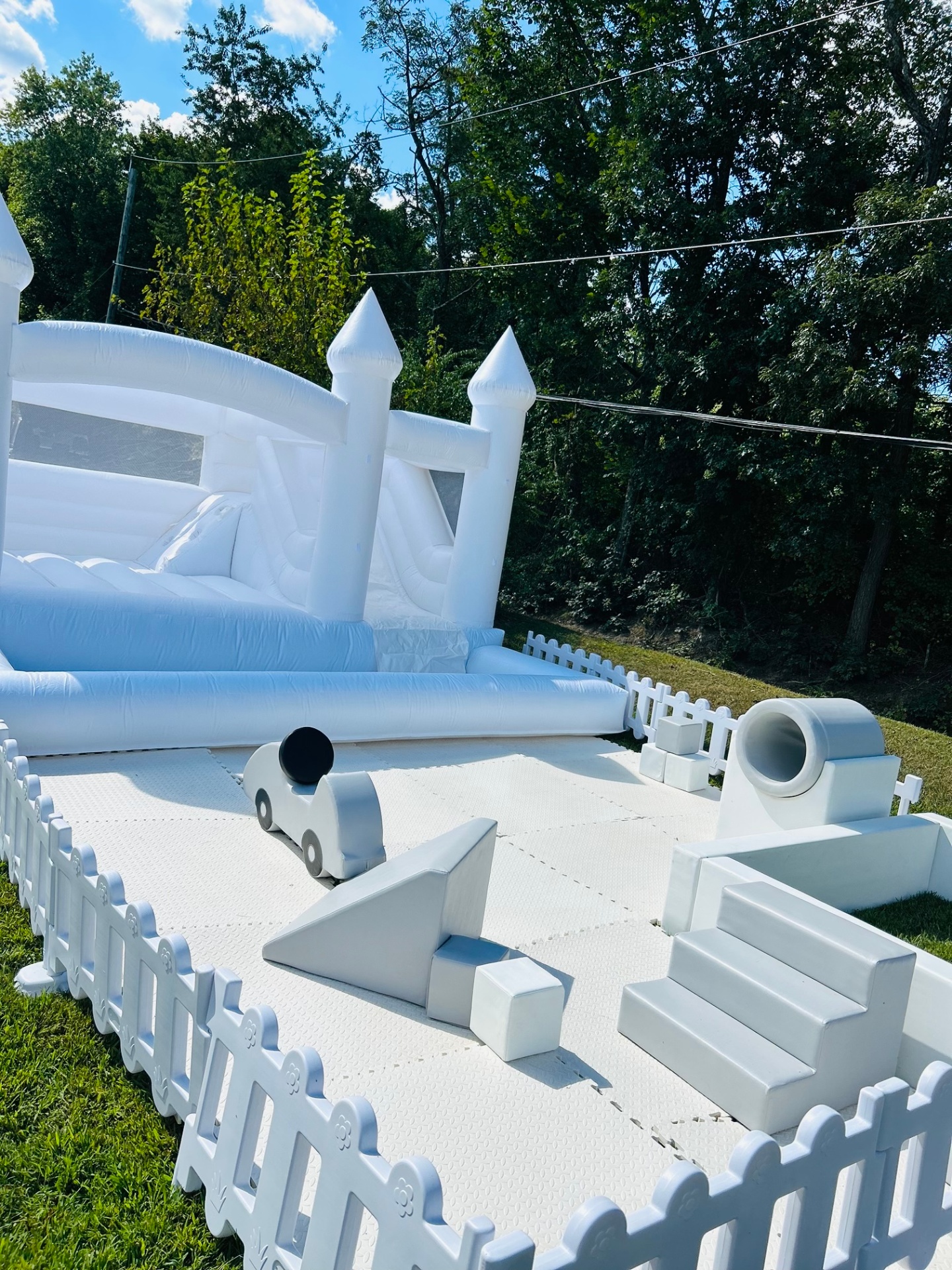White bounce house with slide and soft play add-on