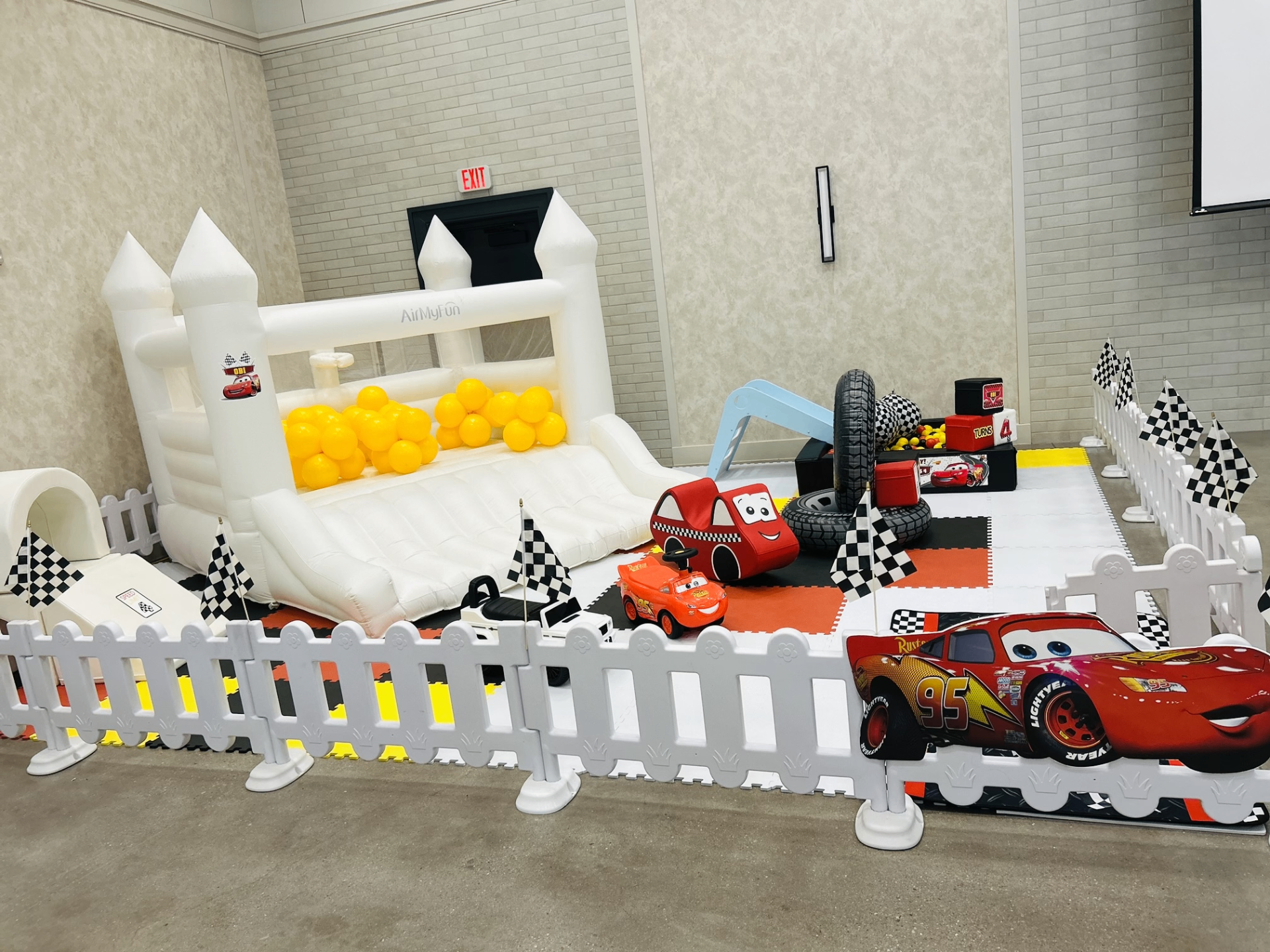 Mini Joy Cars themed setup with white bounce house